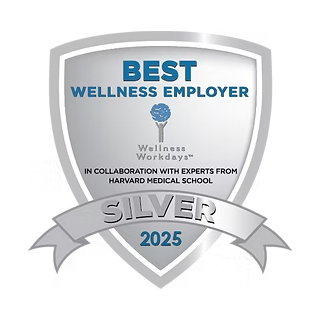 A silver shield badge that reads "Best Wellness Employer" at the top, with "Silver" at the bottom and "2025" in blue. The badge also states "Wellness Workdays in collaboration with experts from Harvard Medical School."